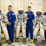   In the Integration Facility at the Baikonur Cosmodrome in Kazakhstan, Expedition 44 crewmembers Kjell Lindgren of NASA (left), Oleg Kononenko of the Russian Federal Space Agency (Roscosmos, center) and Kimiya Yui of the Japan Aerospace Exploration Agency (right) pose with their Sokol launch and entry suits July 11 after a fit check dress rehearsal session. The trio will launch July 23, Kazakh time from Baikonur in their Soyuz TMA-17M spacecraft for a five-month mission on the International Space Station. Credit: Gagarin Cosmonaut Training Center